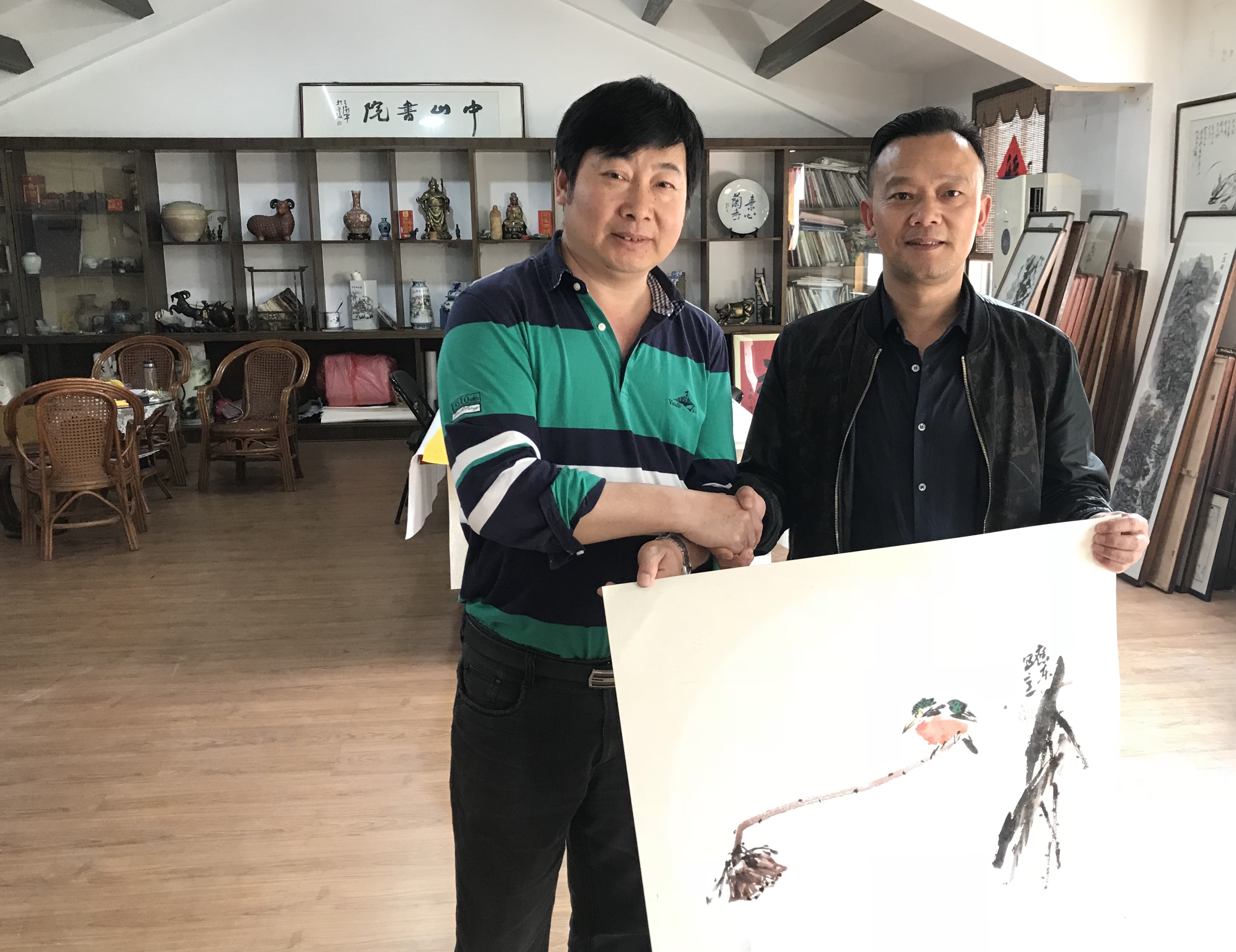 2019年4月6日严家军院长收藏画家李应东先生的作品，并相互握手致意