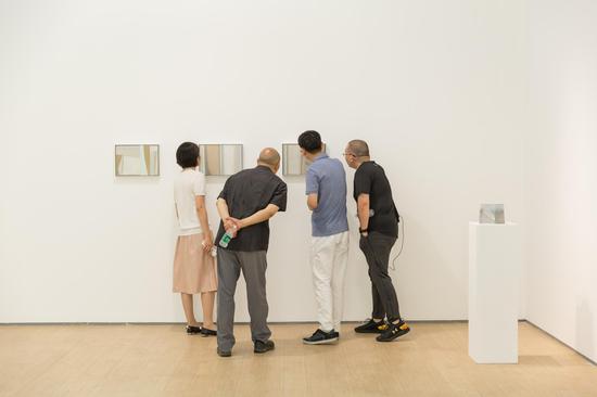 艺术家王豪（右二）、蜂巢执行馆长佟娟娟（左一）陪同艺术家段建伟（左二）及其友人欣赏作品