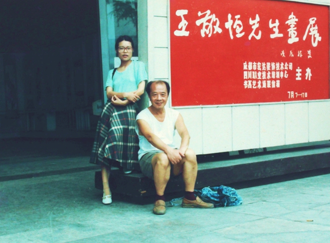 1988（62岁）与葛凤珍在四川省美术展览馆“王敬恒先生画展”展板前合影。